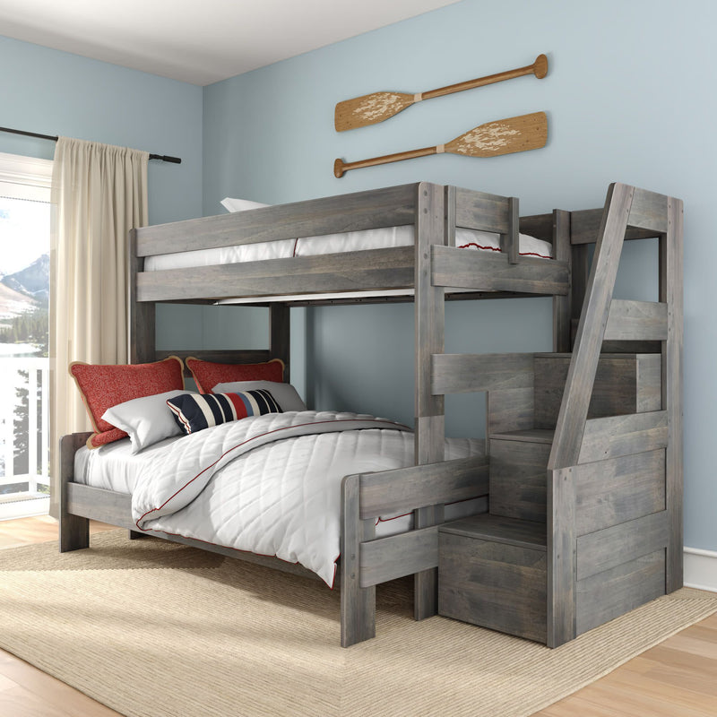 Gray wooden full-over-full bunk bed with stair storage, white quilted bedding and red pillows in light-blue kids room with oar wall decor
