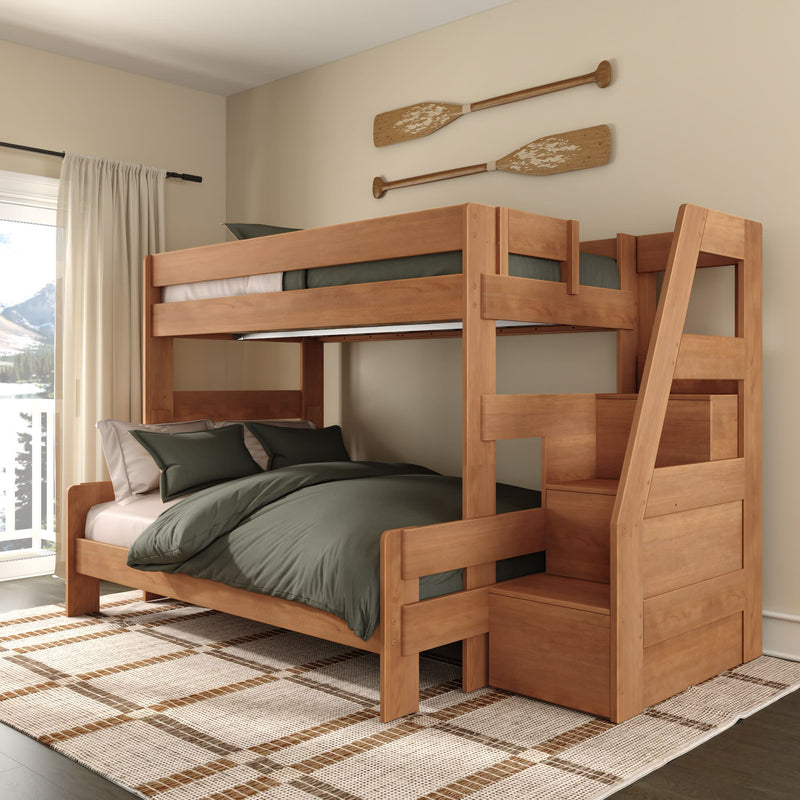 Solid wood twin-over-full bunk bed with built-in storage stairs, green bedding and decorative oars in a modern coastal bedroom