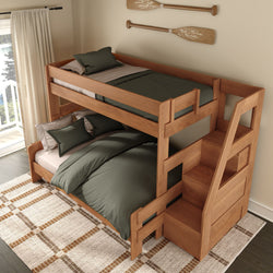 Natural wood twin-over-full bunk bed with built-in staircase storage, green bedding, and coastal oar wall decor in bright bedroom
