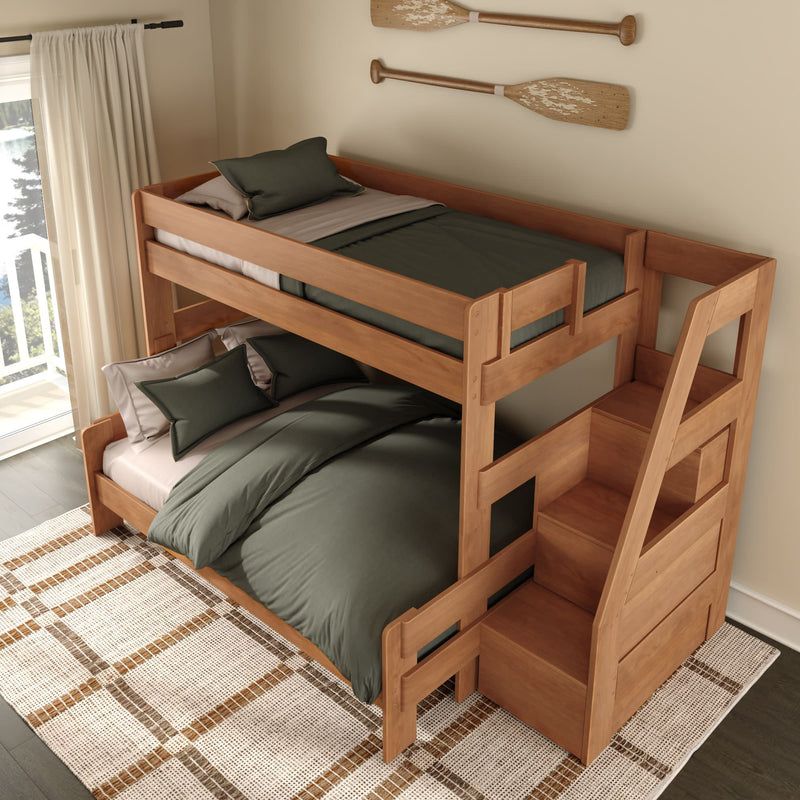Natural wood twin-over-full bunk bed with built-in staircase storage, green bedding, and coastal oar wall decor in bright bedroom