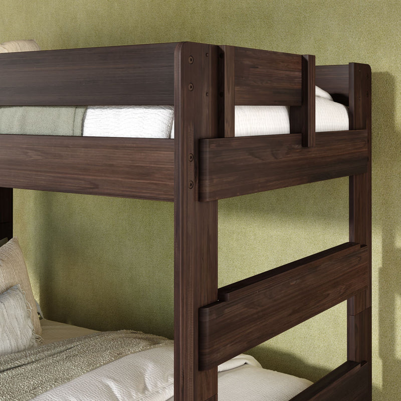 Dark walnut finish solid wood twin-over-twin bunk bed with safety rails and ladder, white and green bedding against a textured green bedroom wall