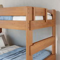 Solid wood twin bunk bed with natural oak finish, blue linens and guardrails in a modern space-saving kids' bedroom