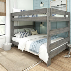 Gray wooden twin-over-full bunk bed in coastal-style bedroom with blue shiplap wall, white bedding, striped pillows and woven jute rug