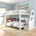 White wood full-over-full bunk bed with staircase storage in coastal bedroom, nautical oar wall decor and lake-view window