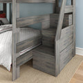 Gray wood kids' bunk bed with built-in storage stairs and drawers, twin-over-twin, white quilted bedding in modern bedroom