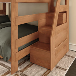 Solid wood bunk bed with built-in storage staircase, dark green bedding, and woven area rug in a space-saving kids' bedroom