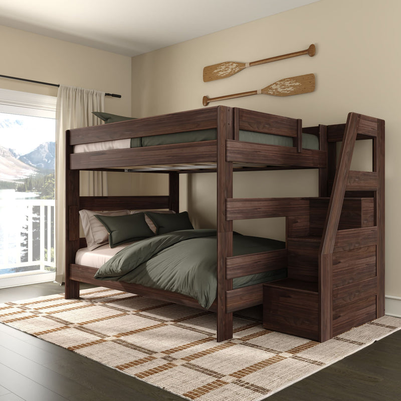 Rustic dark walnut twin-over-full bunk bed with staircase storage, green bedding, plaid rug and wooden oars wall decor in a lakeview bedroom