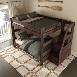 Dark walnut twin-over-full wooden bunk bed with built-in storage stairs, green bedding and pillows on a patterned rug in a bright lakeside bedroom with sliding glass door balcony