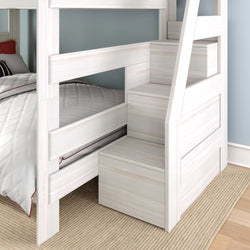 Modern white wooden bunk bed with built-in storage staircase, gray quilted bedding, blue wall and woven rug
