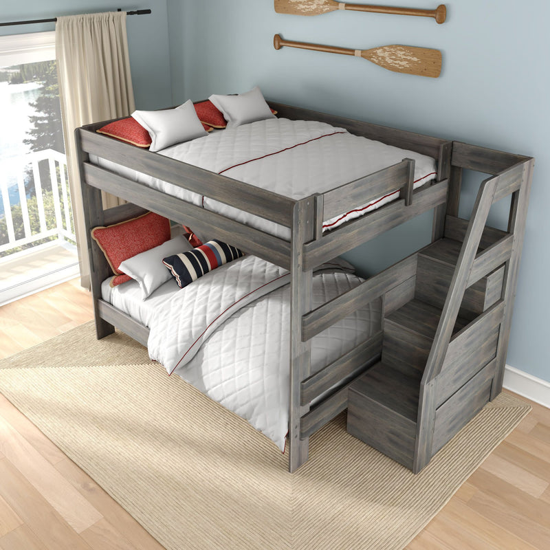 Gray wooden twin-over-full bunk bed with built-in storage stairs, white quilted bedding and red accent pillows, nautical oar wall decor and balcony light