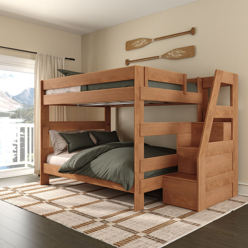 Solid wood twin-over-full bunk bed with storage stairs, green bedding, plaid rug and decorative oars in bright bedroom with balcony mountain-lake view