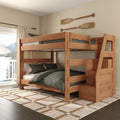 Solid wood twin-over-full bunk bed with storage stairs, green bedding, plaid rug and decorative oars in bright bedroom with balcony mountain-lake view
