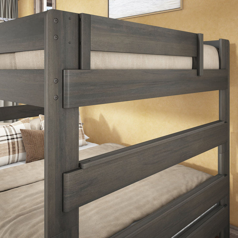 Gray-stained solid wood bunk bed with full-length guardrails, beige bedding and plaid pillows in a modern kids' bedroom close-up