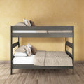 Gray wooden bunk bed with beige bedding and plaid pillows in a modern bedroom against a yellow textured wall and wood plank floor.