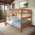 Solid wooden bunk bed with blue bedding in a rustic farmhouse bedroom overlooking pine trees and a lake
