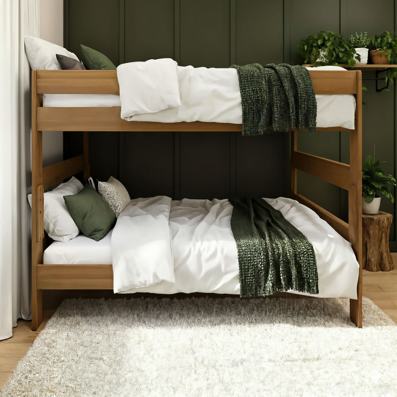 Wooden bunk bed with white linens and green throw blankets and pillows in a cozy modern bedroom with dark green paneled wall, shag rug, and potted plants