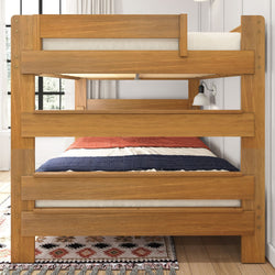 Wooden bunk bed with colorful bedding and a stylish area rug in a bright bedroom.
