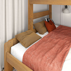 Cozy loft bed with wooden frame, soft pillows, and a warm orange blanket in a modern bedroom setting.