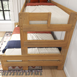 Wooden bunk bed with colorful bedding and patterned rug in a bright bedroom.