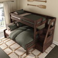 Walnut twin-over-full wooden bunk bed with staircase storage drawers, green bedding and pillows, coastal oar wall decor, natural woven rug and balcony window — modern rustic kids' bedroom furniture