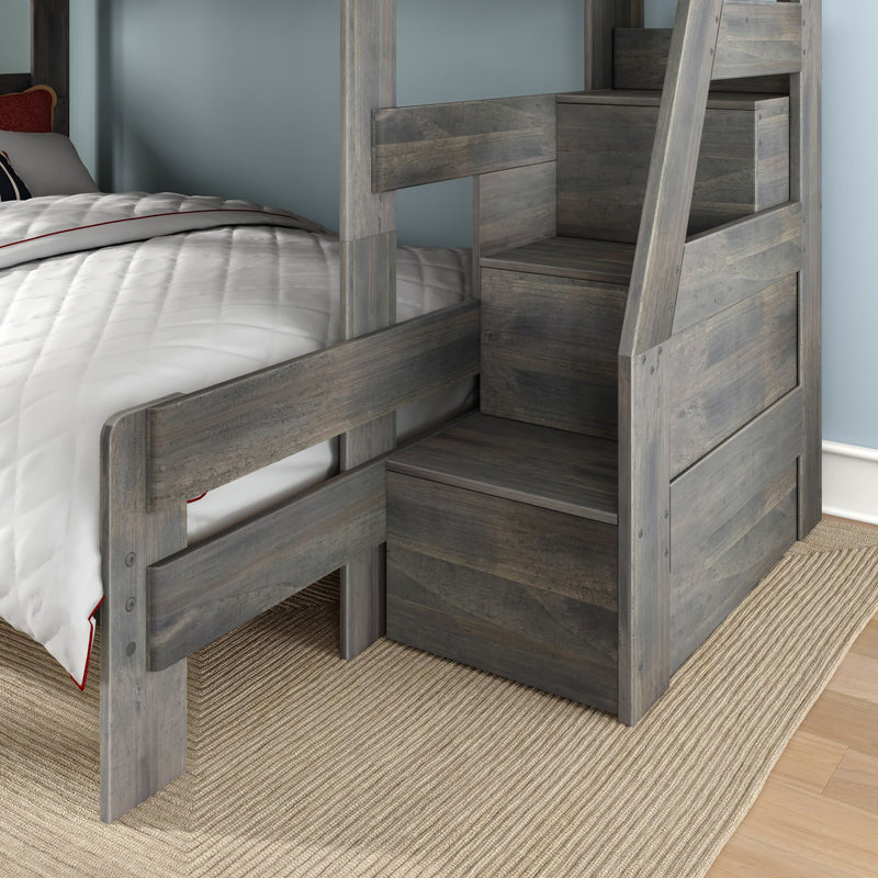 Grey wooden twin-over-twin bunk bed with built-in storage staircase drawers, white quilted bedding and woven rug in modern kids' bedroom
