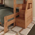 Solid wood bunk bed with built-in storage stairs, natural finish, gray bedding and woven rug in a cozy modern bedroom