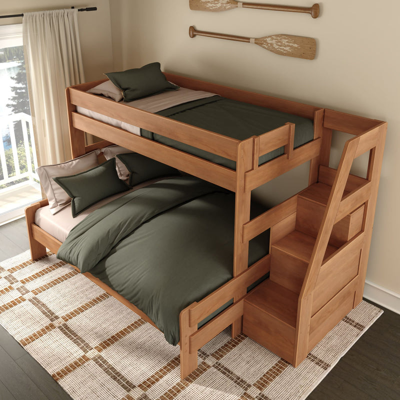 Solid wood full-over-twin bunk bed with storage staircase and drawers, oak finish and green bedding in a space-saving kids' bedroom design
