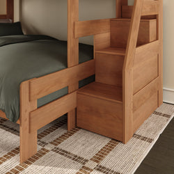 Space-saving solid wood bunk bed with built-in storage staircase, dark gray bedding and patterned rug in modern bedroom