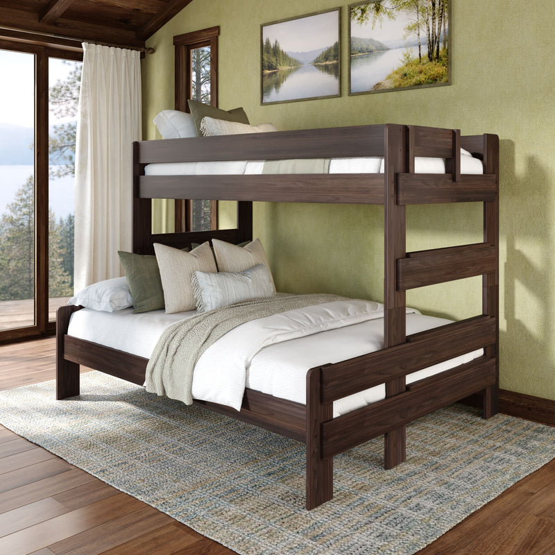 Dark walnut solid wood twin-over-full bunk bed in cozy lakeside bedroom with layered white bedding, decorative throw pillows and green accent walls — space-saving bunk bed for kids and guests