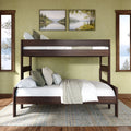 Dark wood full-over-twin bunk bed in a cozy green bedroom with white bedding, layered pillows, neutral throw, area rug and lake-view windows