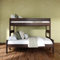 Dark wood twin-over-full bunk bed with white linens and green accent pillows against a textured green wall on hardwood floor