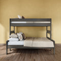 Dark gray wooden bunk bed with a full-size lower bed and twin upper bed, beige bedding and plaid pillows in a modern bedroom with yellow textured wall and hardwood floor