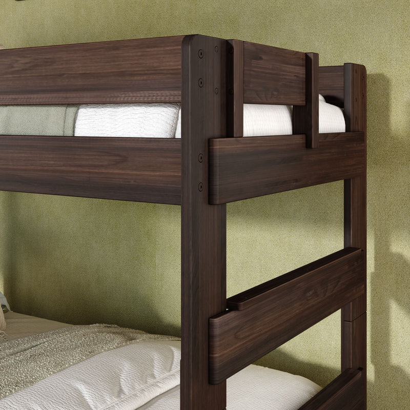 Close-up of dark walnut solid wood twin bunk bed with safety rails and ladder, white bedding and textured green bedroom wall