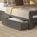Gray wooden bunk bed with pull-out trundle storage drawer, beige textured bedding and plaid throw pillows on cream rug