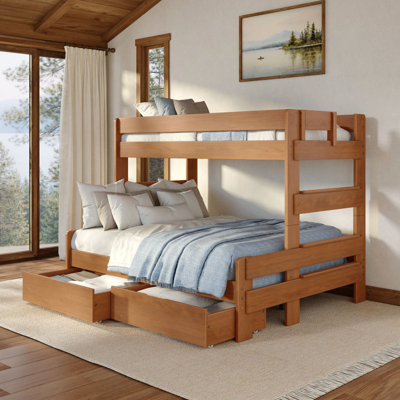 Sunlit cabin bedroom featuring a rustic wooden bunk bed with pull-out trundle drawers, blue bedding, soft pillows, and a framed lake painting