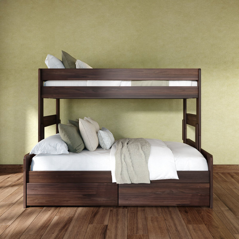 Dark walnut bunk bed with white linens, green and beige pillows and a knit throw against an olive textured wall on hardwood floor
