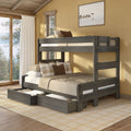 Rustic wooden bunk bed with pull-out trundle drawers in cozy cabin bedroom with neutral bedding and plaid pillows