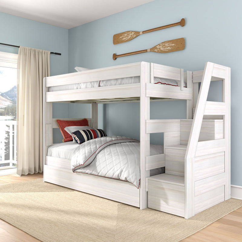 Whitewashed wooden twin-over-full bunk bed with built-in storage stairs in coastal-style kids' bedroom with light blue walls, nautical oar wall decor, striped pillows and window mountain view