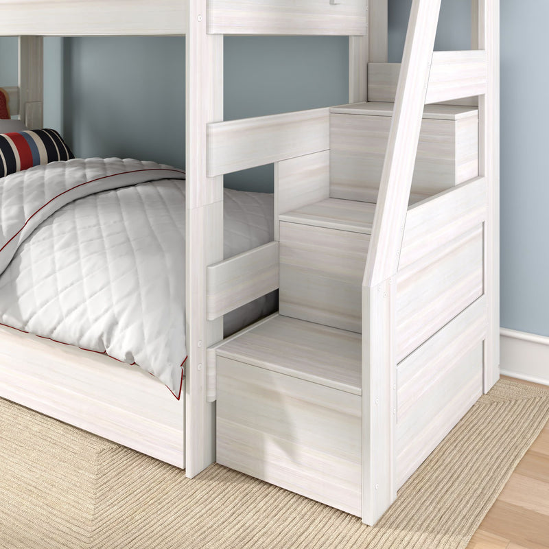 White wooden bunk bed with built-in storage stairs and drawers, lower twin bed with quilted white comforter and striped pillow in a children's bedroom