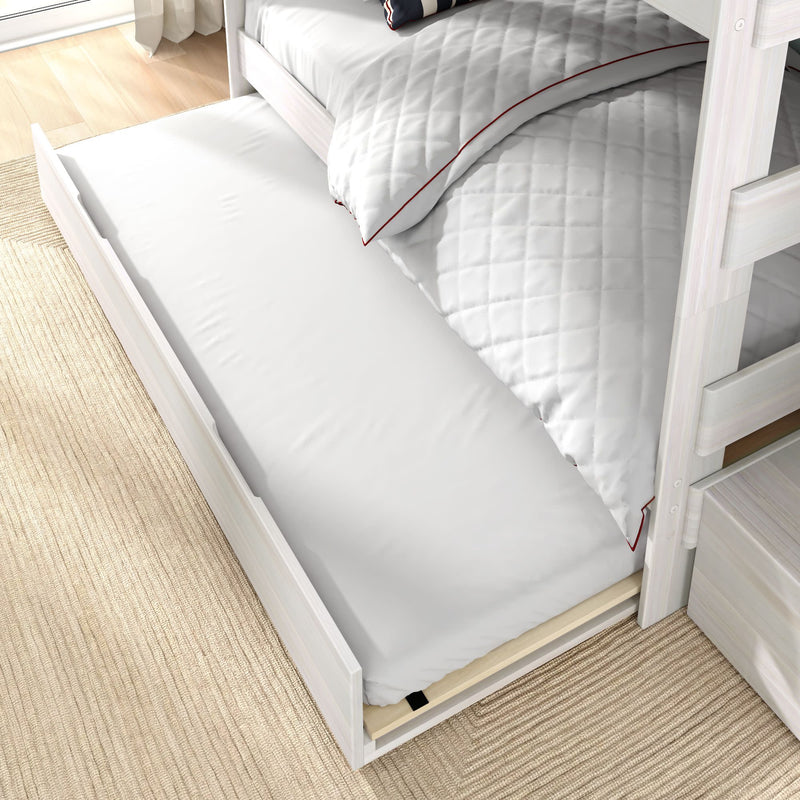 Underbed trundle mattress pulled out from whitewashed light wood bunk bed with quilted white duvet on beige rug — space-saving storage for kids' bedroom.