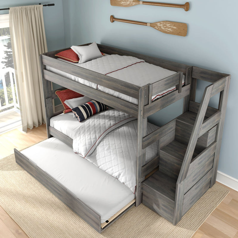 Gray wooden bunk bed with built-in storage stairs and pull-out trundle mattress, white quilted bedding and nautical accent pillows in a coastal-style kids bedroom with paddle wall decor and balcony light