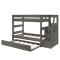 Gray wooden twin-over-full bunk bed with built-in storage staircase, slatted mattress support, and under-bed pull-out trundle in rustic gray finish