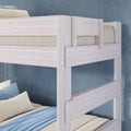 Light-wash wooden twin-over-twin bunk bed with guardrails, blue and beige striped pillows and soft blue bedding against a textured blue-gray wall