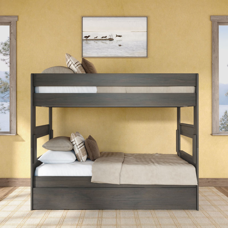 Dark gray wooden twin-over-full bunk bed with beige bedding and plaid pillows in a cozy yellow-walled bedroom with lake artwork and windows