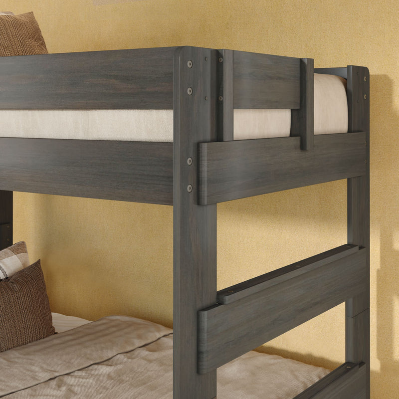 Modern dark gray wooden twin bunk bed with safety rails and neutral beige bedding against textured wall