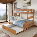 Solid wood bunk bed with pull-out trundle and blue-gray bedding in a cozy modern rustic lakeside bedroom with large panoramic window and pine forest view
