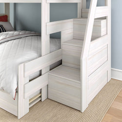 White wooden bunk bed with built-in storage stairs, white quilted bedding and beige rug in a modern kids' bedroom