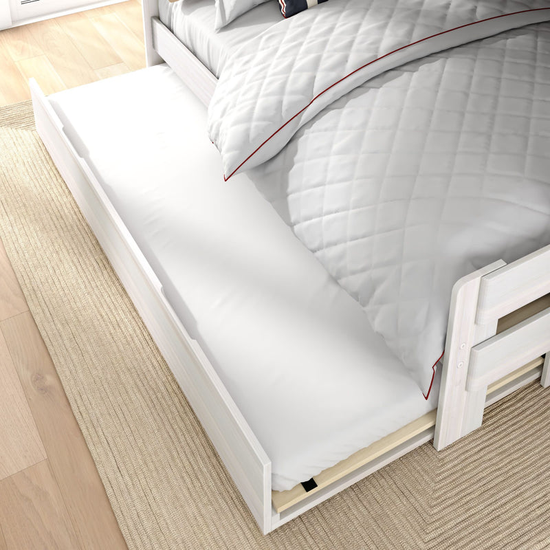 White wooden trundle bed with pull-out mattress under twin bed, grey quilted duvet with red piping on light wood floor and natural rug