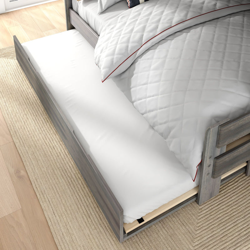 Gray wooden trundle bed pulled out beneath twin bed with white quilted bedding on natural rug — space-saving guest or kids storage bed