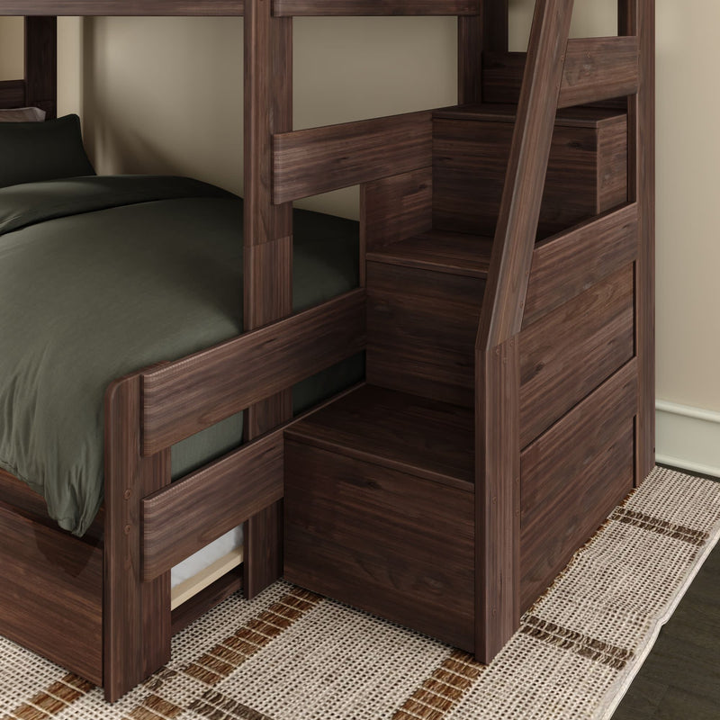 Dark walnut wooden twin-over-twin bunk bed with built-in staircase storage drawers, dark green bedding and woven rug in a space-saving modern kids' bedroom